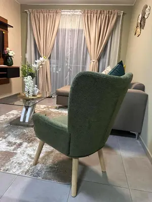 a living room with a green chair and a couch at Olive view Retreat in Midrand