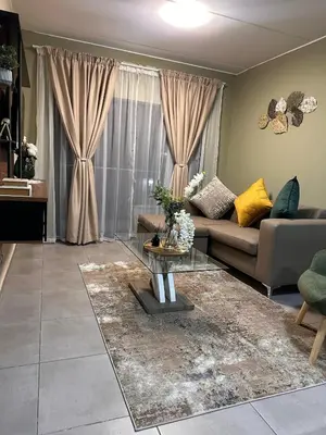a living room with a couch and a table at Olive view Retreat in Midrand
