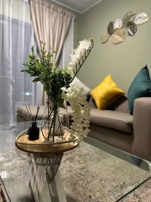 a living room with a table with flowers on it at Olive view Retreat in Midrand