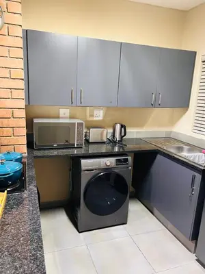 a kitchen with a microwave and a dishwasher at Olive view Retreat in Midrand