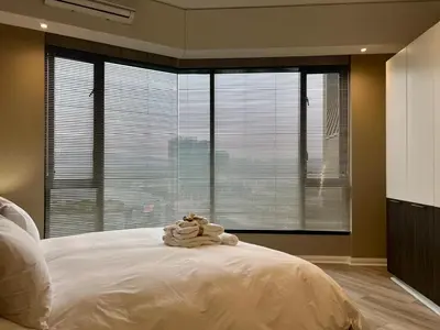 a bedroom with a large bed and a large window at Deluxe fully furnished apartment in Menlyn Maine residence 1209 in Pretoria