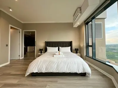 a bedroom with a large bed and a large window at Deluxe fully furnished apartment in Menlyn Maine residence 1209 in Pretoria