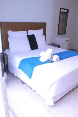 a large white bed with a hat on top of it at Fargon Guest House in Polokwane
