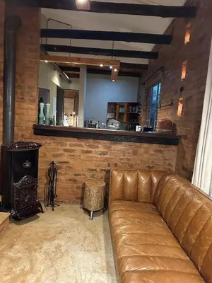 a living room with a leather couch and a bar at Wild Fig Cottage with Tickle Tub in Hartbeespoort in Pelindaba