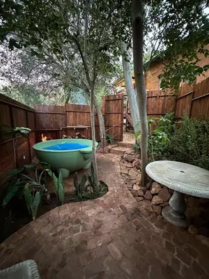 a bath tub sitting in the middle of a yard at Wild Fig Cottage with Tickle Tub in Hartbeespoort in Pelindaba