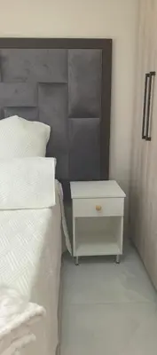 a bedroom with a white bed and a night stand at Ee40Yethu in Pretoria