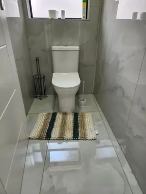 a bathroom with a toilet and a rug on the floor at Ee40Yethu in Pretoria