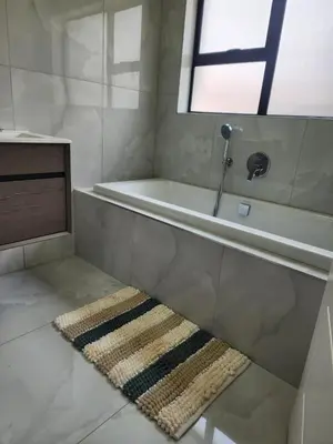 a bathroom with a bath tub and a rug on the floor at Ee40Yethu in Pretoria