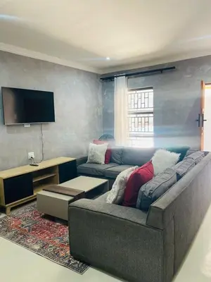 a living room with a couch and a tv at Kruger Place in Mokopane