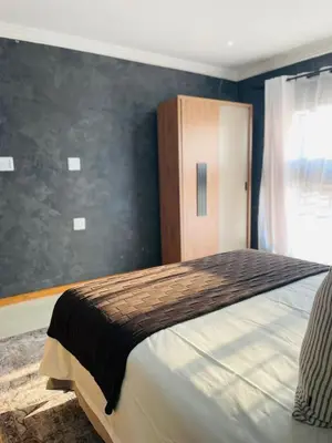 a bedroom with a large bed and a cabinet at Kruger Place in Mokopane