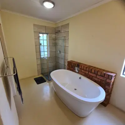 a bathroom with a large tub and a shower at Six Senses in Marloth Park