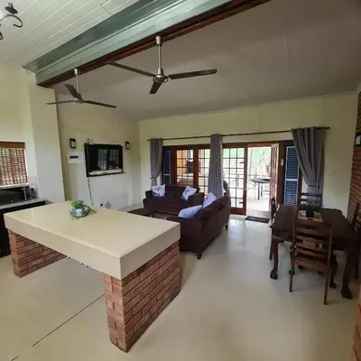 a living room with a couch and a table at Six Senses in Marloth Park