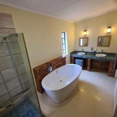 a large bathroom with two sinks and a large tub at Six Senses in Marloth Park