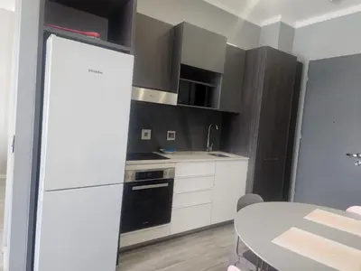 a kitchen with black and white cabinets and a table at Menlyn Maine Residences 1317 in Pretoria