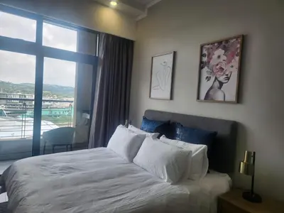 a bedroom with a bed and a large window at Menlyn Maine Residences 1317 in Pretoria