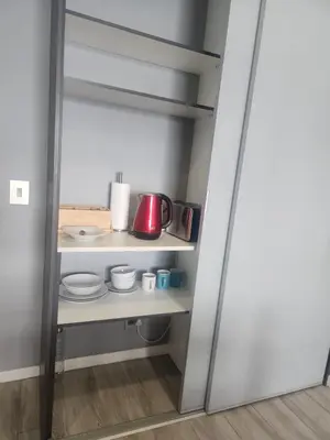 a kitchen with white shelves and a red appliance at Menlyn Maine Residences 1317 in Pretoria