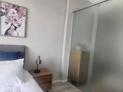 a bedroom with a glass shower door next to a bed at Menlyn Maine Residences 1317 in Pretoria