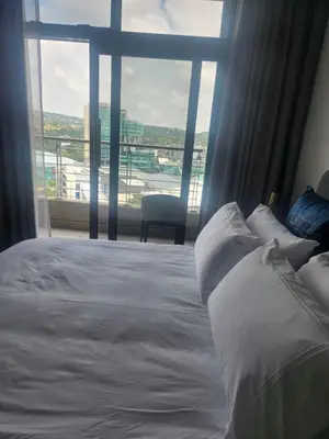 a bedroom with a white bed and a large window at Menlyn Maine Residences 1317 in Pretoria