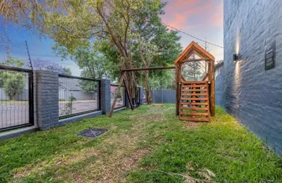 a backyard with a wooden gate next to a building at Madumane Self Catering in Hildreth Ridge