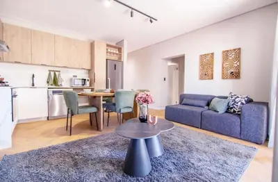 a living room with a blue couch and a table at Madumane Self Catering in Hildreth Ridge