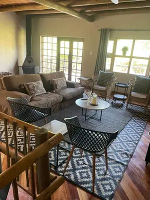 a living room with a couch and chairs and a table at Botterblom Hide-Away in Sabie