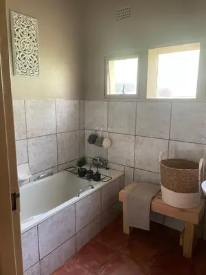 a bathroom with a tub and a sink at Botterblom Hide-Away in Sabie