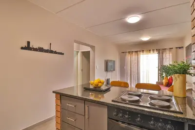 a kitchen with a stove and a counter top at The Place at Waterfall in Midrand