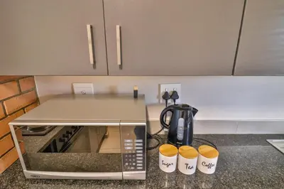 a kitchen counter with a coffee pot and cups on it at The Place at Waterfall in Midrand