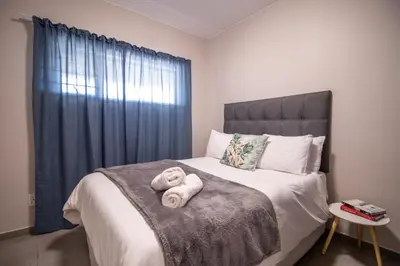 a bedroom with a bed with towels on it at The Place at Waterfall in Midrand