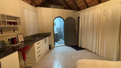 a kitchen with a hallway with an archway and a sink at Aneiwa airport lodge in Kempton Park