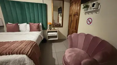 a hotel room with a bed and a chair at Aneiwa airport lodge in Kempton Park