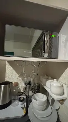a shelf with a mirror and a bunch of dishes at Aneiwa airport lodge in Kempton Park