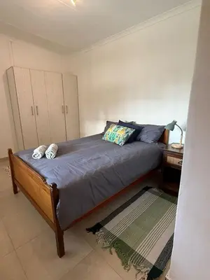 a bedroom with a large bed with a night stand and a table at Wittus Retreat in White River