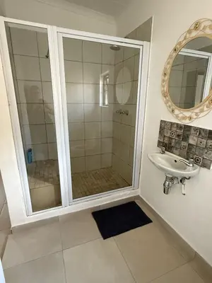 a bathroom with a shower and a sink at Wittus Retreat in White River