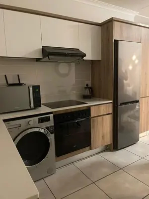 a kitchen with a washing machine and a microwave at The Blyde Crystal Lagoon in Pretoria