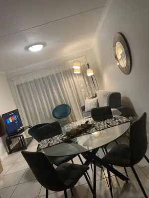 a living room with a glass table and chairs at The Blyde Crystal Lagoon in Pretoria