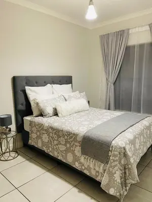 a bedroom with a large bed with white pillows at The Blyde Crystal Lagoon in Pretoria