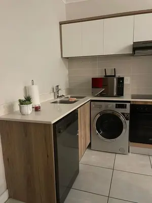 a kitchen with a sink and a washing machine at The Blyde Crystal Lagoon in Pretoria