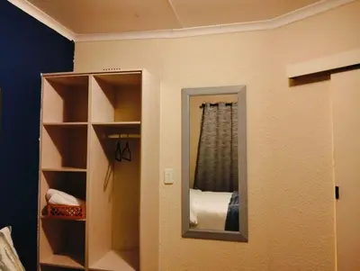 a mirror on a wall in a room at Aneiwa airport lodge in Kempton Park
