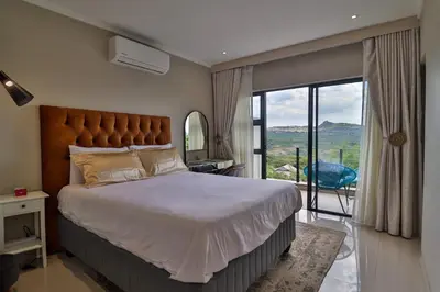 a bedroom with a large bed and a large window at Perfect Hideaway in Nelspruit