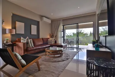a living room with a leather couch and a table at Perfect Hideaway in Nelspruit