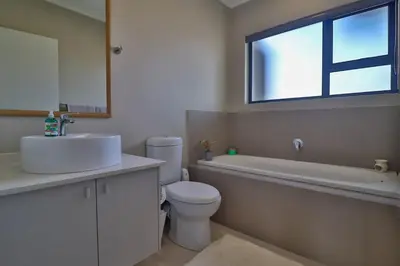 a bathroom with a sink and a toilet and a window at Perfect Hideaway in Nelspruit