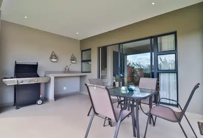 a dining room with a table and chairs and a desk at Perfect Hideaway in Nelspruit