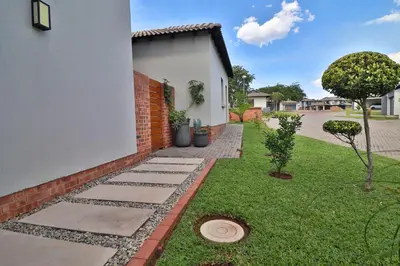 a garden with a brick wall and a lawn at Perfect Hideaway in Nelspruit