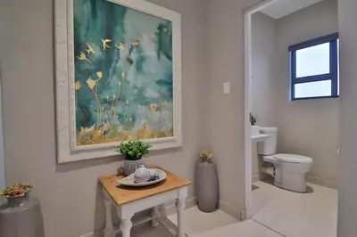 a bathroom with a toilet and a painting on the wall at Perfect Hideaway in Nelspruit