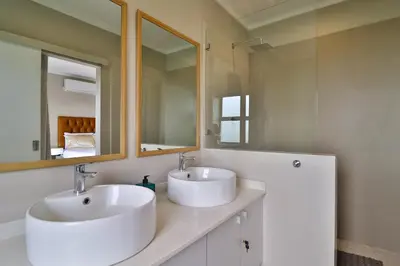 a bathroom with two sinks and a mirror at Perfect Hideaway in Nelspruit