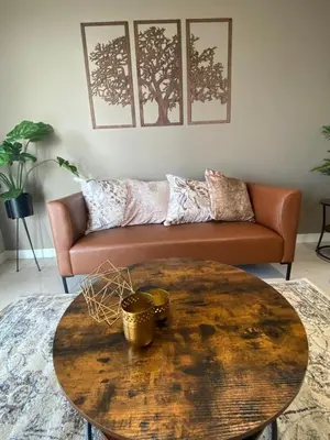 a living room with a couch and a wooden table at Stunning 2 bedroom condo at Ellipse Midrand in Midrand