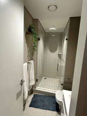 a bathroom with a shower and a toilet and a sink at Stunning 2 bedroom condo at Ellipse Midrand in Midrand