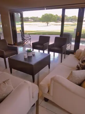 a living room with couches and a table and chairs at Pecanwood Relaxing Villa - Golf, Pool, Braai & Dam Views in Hartbeespoort