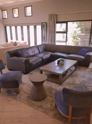 a living room with a couch and a coffee table at Pecanwood Relaxing Villa - Golf, Pool, Braai & Dam Views in Hartbeespoort